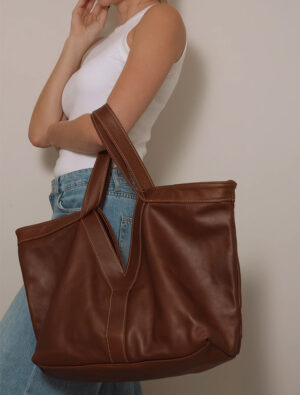 woman holding brown leather hand bag